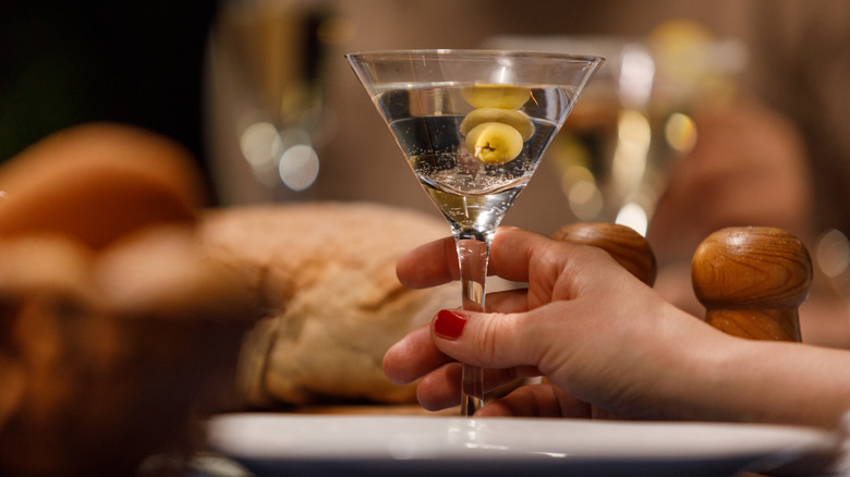 woman's hand holding dirty martini