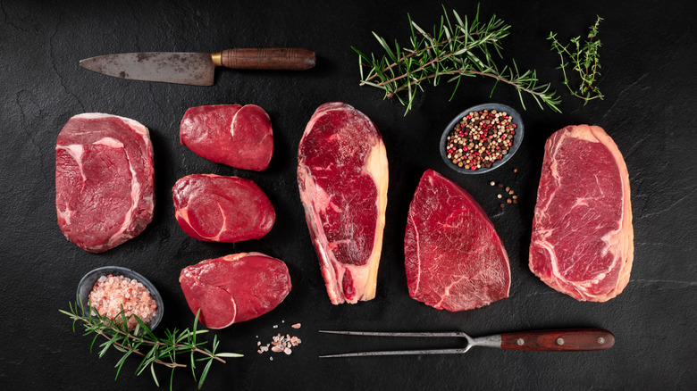 Raw cuts of meat on black background