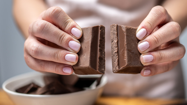 Woman breaking up chocolate