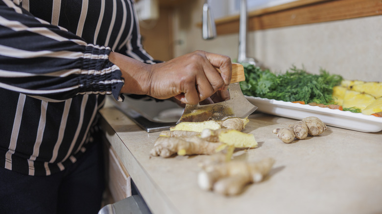 Person chopping ginger root