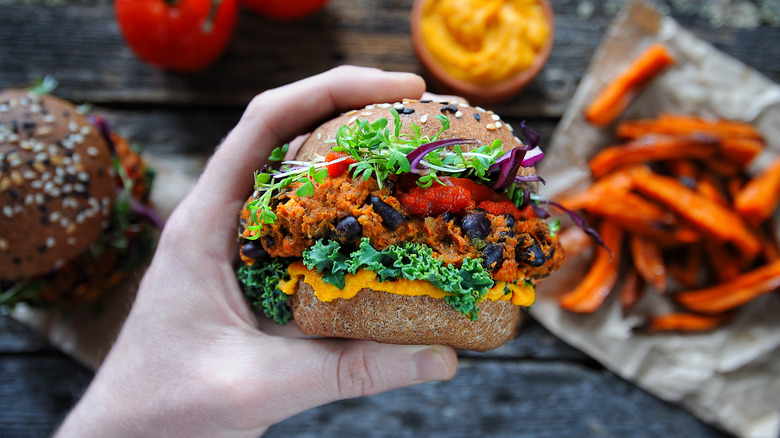 Hand holding sweet potato burger