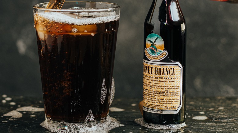 pouring cola over Fernet 