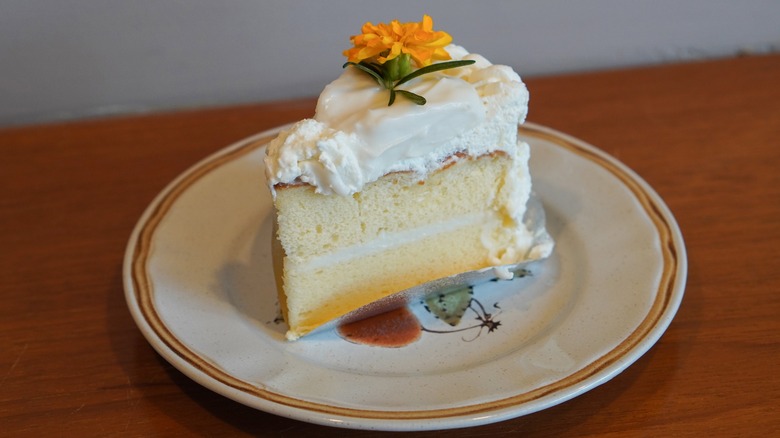 vanilla coconut cream cake slice with marigold flower