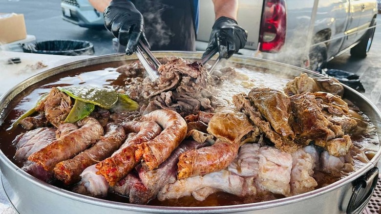 Person grilling mixed meats