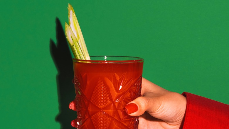 hand holding bloody mary with celery
