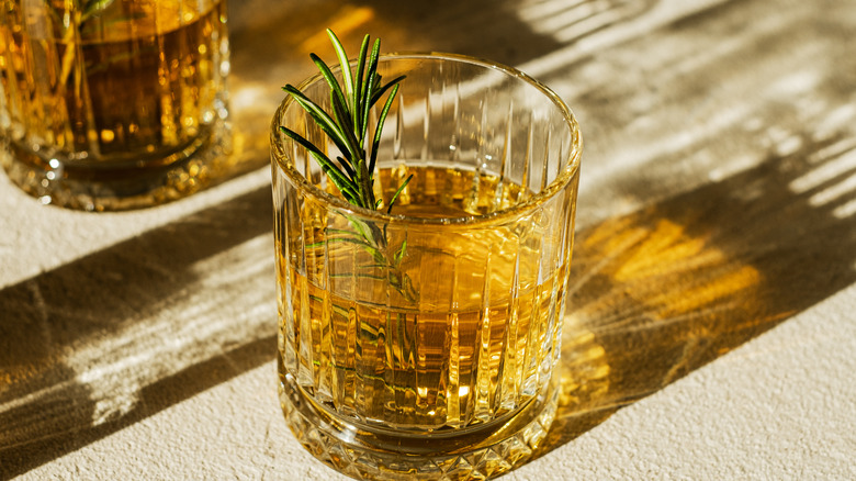 whiskey in a glass with rosemary