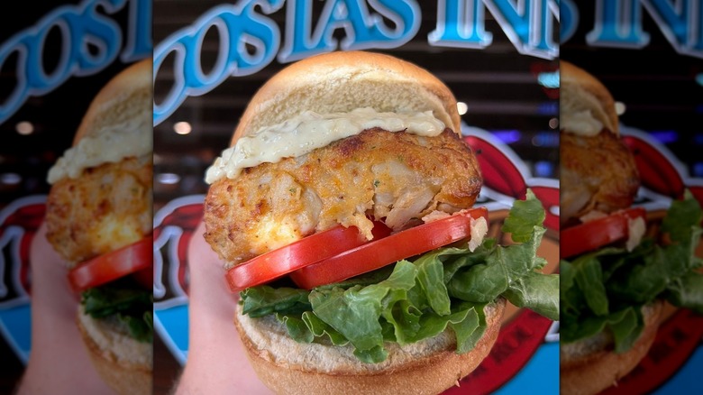 Person holding large crab sandwich