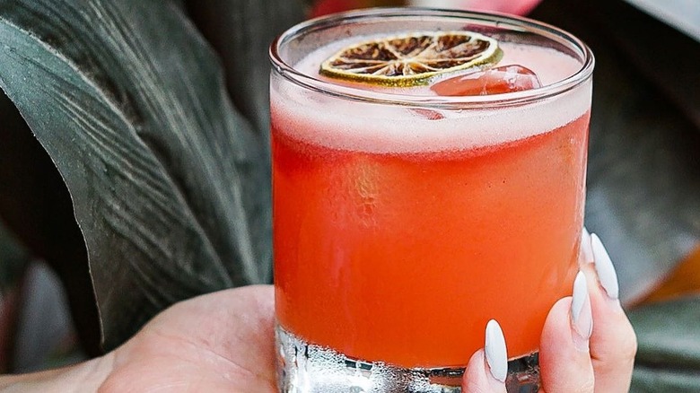 Hand holding orange cocktail