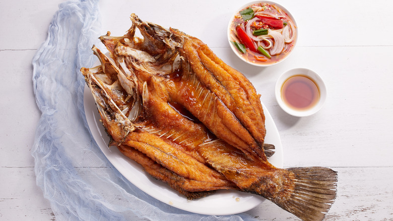 Whole fried bass with condiments