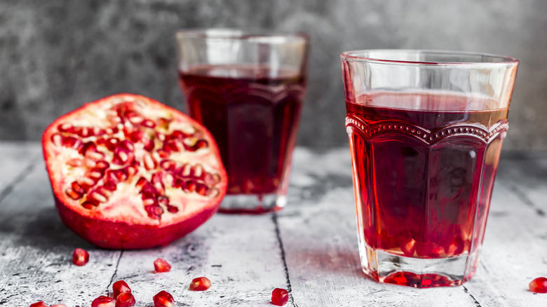 Glasses of pomegranate juice with half of a pomegranate