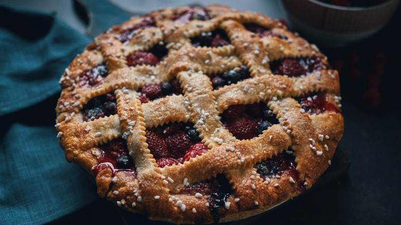 Sugary latticework pie crust on top of a berry pie