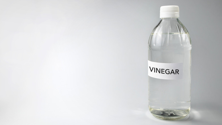 plastic bottle of clear vinegar with label