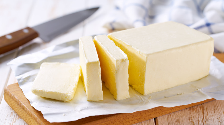 Sliced pieces of butter on wooden cutting board