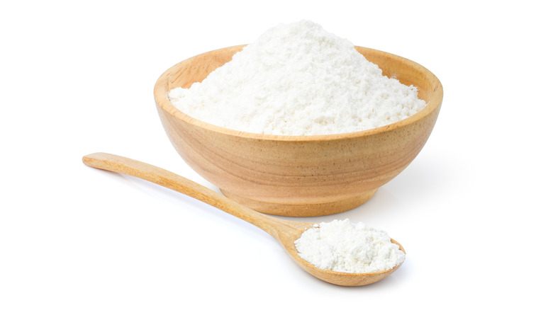 Bowl of tapioca starch with spoon on white background