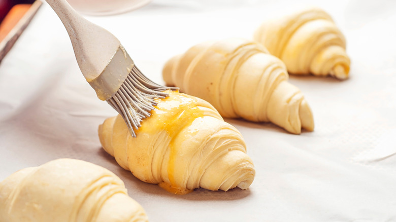 Brushing egg wash on croissants