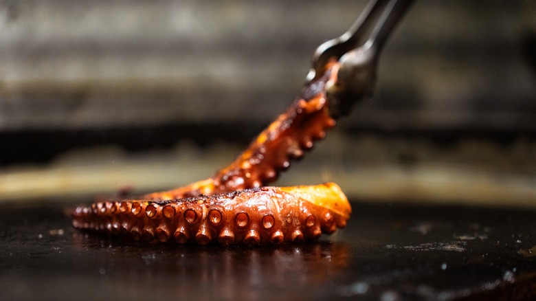 Octopus tentacles cooking on griddle