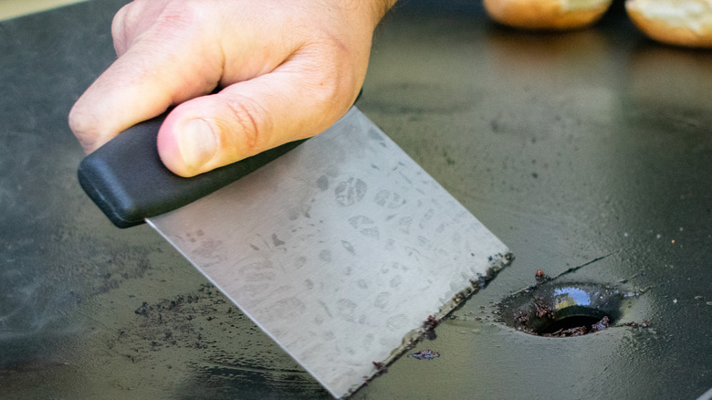 scraping food residue off griddle cooktop 