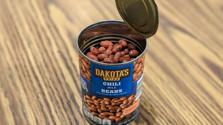 Open can of Dakota's Pride mild chili beans on wood table