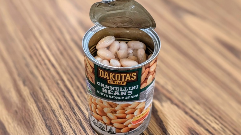 Open can of Dakota's Pride white kidney beans on wood table
