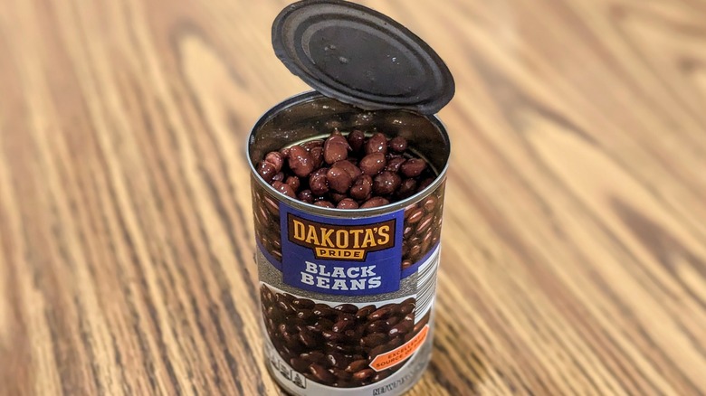 Open can of Dakota's Pride black beans on wood table