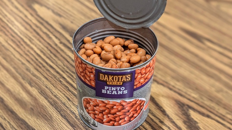 Open extra-large can of Dakota's Pride pinto beans on wood table