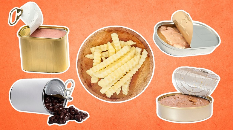 Variety of opened canned foods surrounding a plate of frozen fries against an orange background