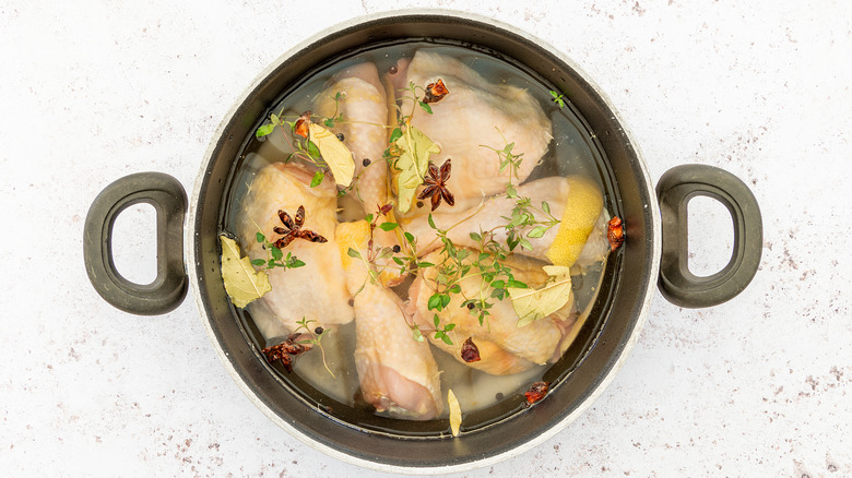 Chicken brining in water with herbs