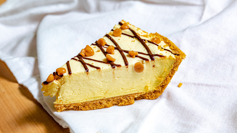 Slice of peanut butter cheesecake on white napkin