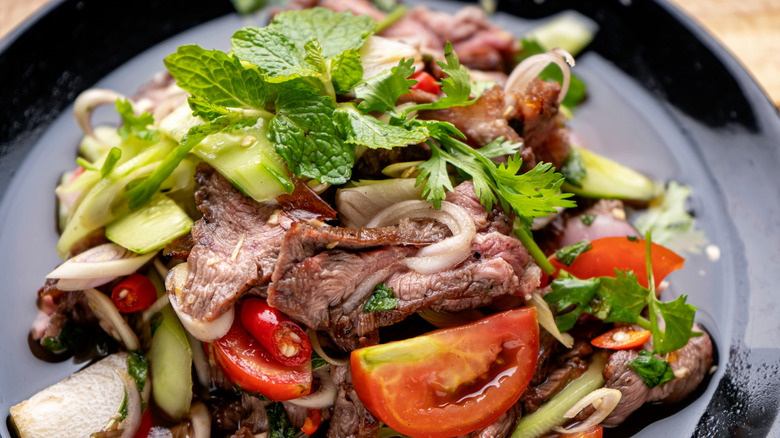 beef salad on black plate