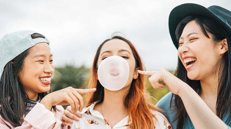 People pointing to a bubblegum bubble