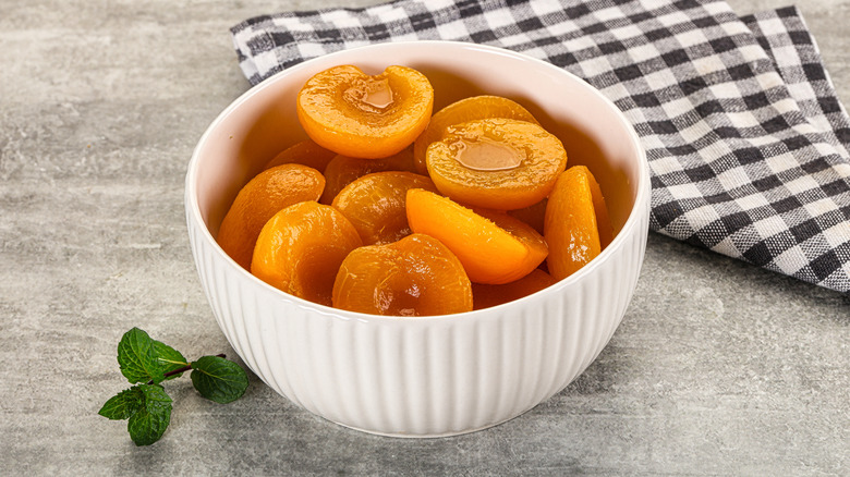 Canned apricot halves in a white bowl