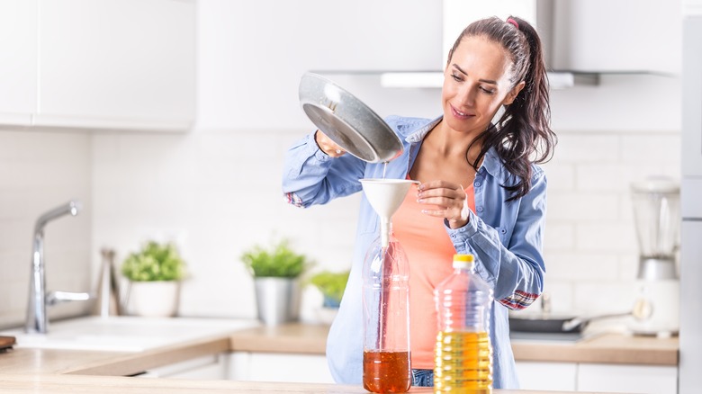 Woman pouring liquid through funnel