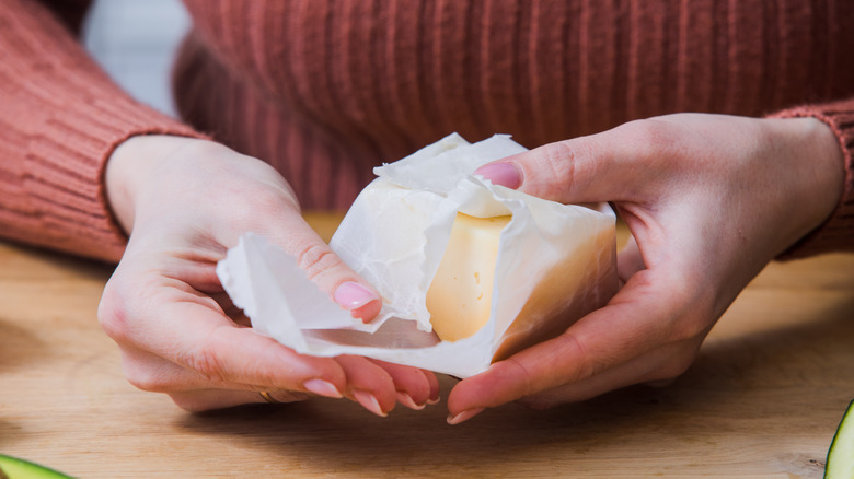 Woman wrapping cheese wax paper