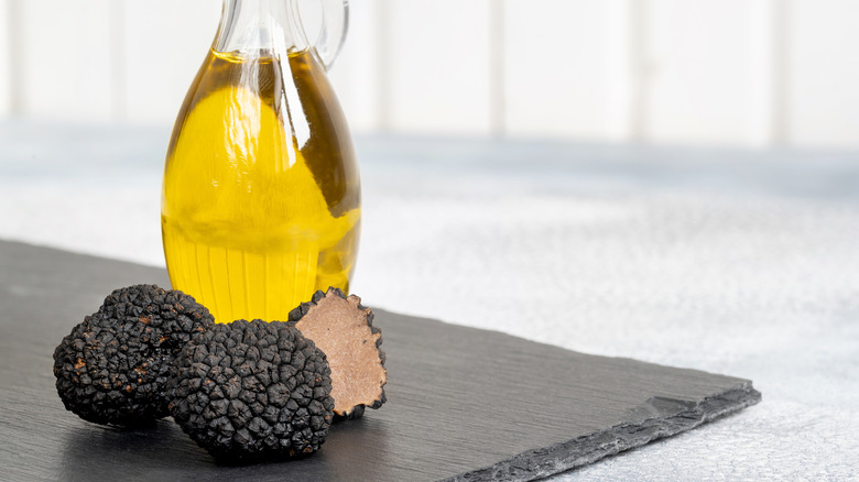 Bottle of truffle oil with whole black truffles