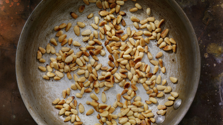 Pine nuts toasting in a pan