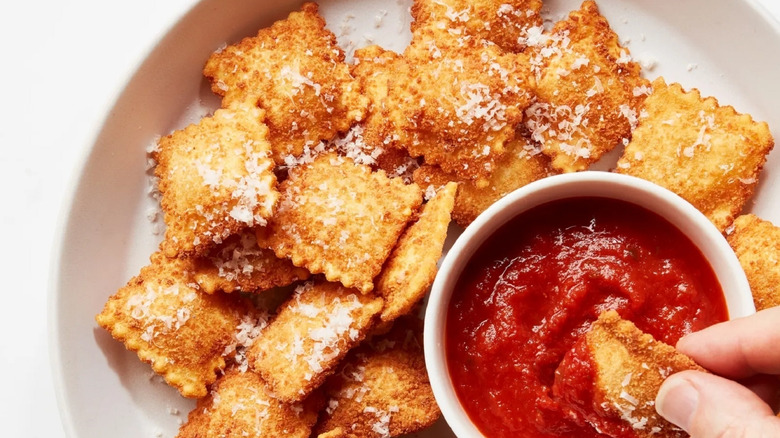 Plate of toasted ravioli with tomato dipping sauce