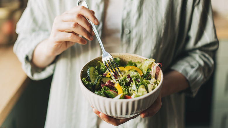 Woman holding loaded salad