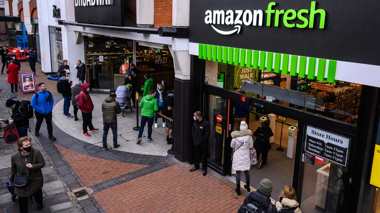 people gathering outside of an Amazon Fresh storefront