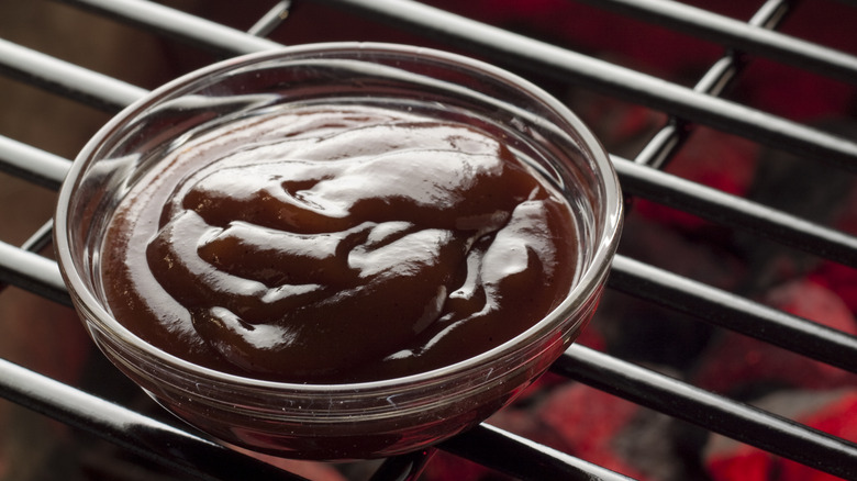 A glass ramekin with BBQ sauce