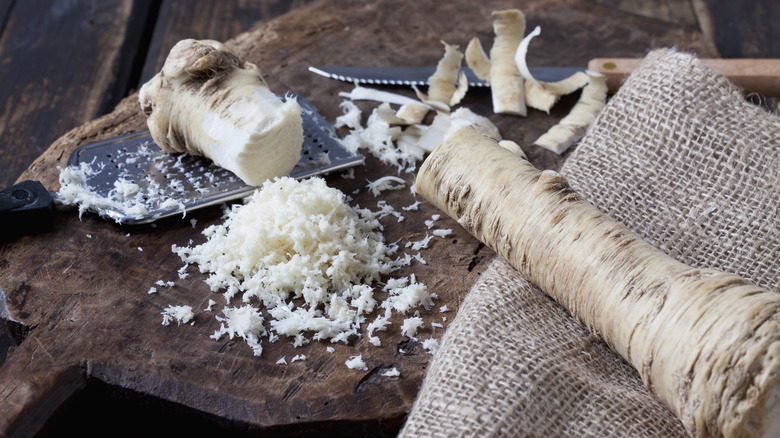 Horseradish being prepared on a tree stump