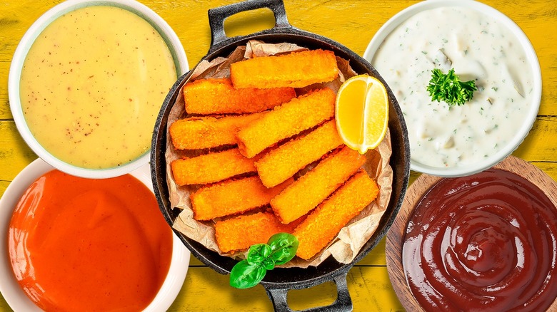 Plate of fish sticks surrounded by dipping sauces