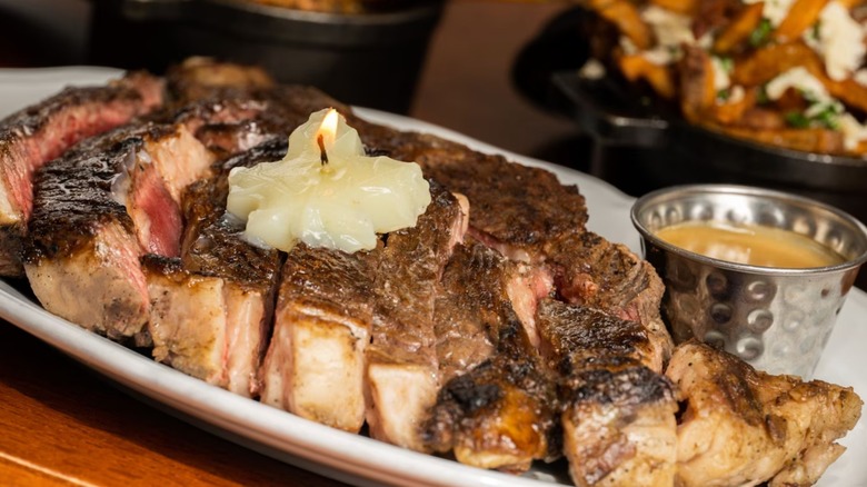 Close up of a steak with candle-lit butter on top