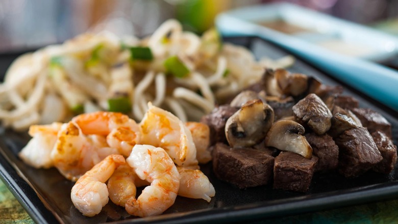 Teppanyaki plate of meat, mushrooms, noodles, and vegetables