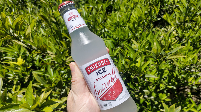 Hand holding bottle of Smirnoff Ice