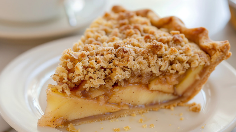 Slice of Dutch-style apple pie with crumble topping on a plate