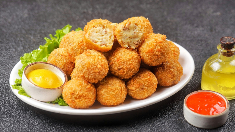 Pile of Dutch deep-fried meatballs on a plate with dipping sauce