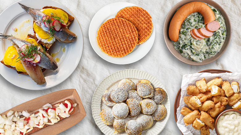 Array of Dutch dishes on plates on top of a white tablecloth