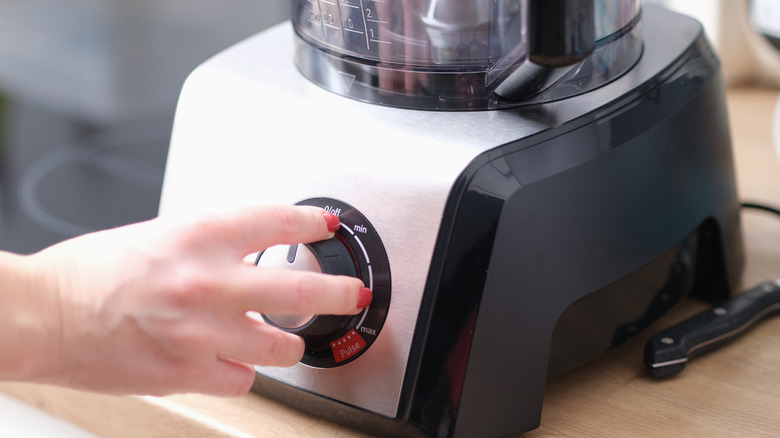 A person setting a blender