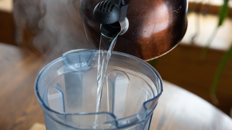 Pouring boiling water from a kettle into a blender