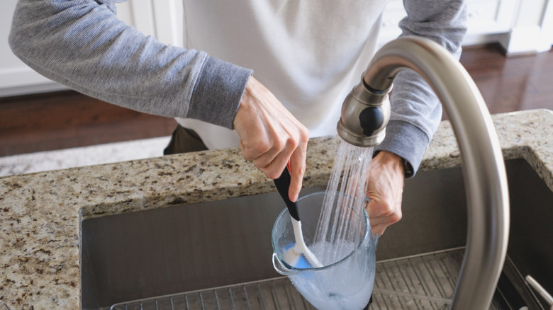A person cleaning a blender jar